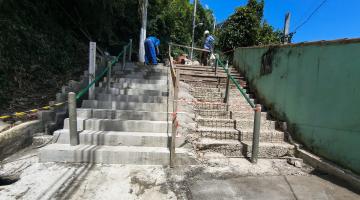 escadaria em obras com dois homens trabalhando no alto. #paratodosverem