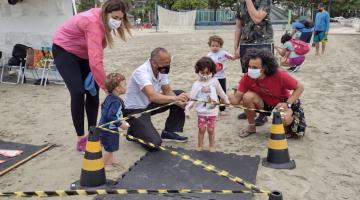Crianças realizam atividades de lazer na areia da praia #paratodosverem