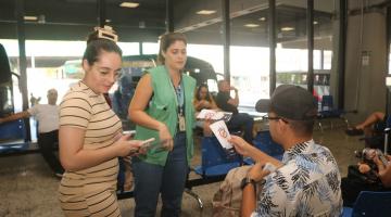 agente entrega panfleto a homem sentado #paratodosverem