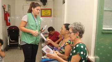 agente entrega panfleto a mulher #paratodosverem 