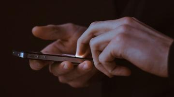 Mãos, em close, seguram e digitam smartphone. #Paratodosverem