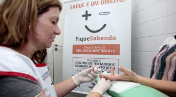 Mulher realiza exame para detecção do hiv em pessoa #paratodosverem