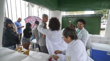 pessoas sendo vacinadas em estande da saúde #paratodosverem