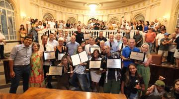 pessoas mostram placas de homenagem #paratodosverem