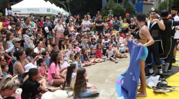 Crianças assistem apresentação em praça ao lado do Aquário. #paratodosverem