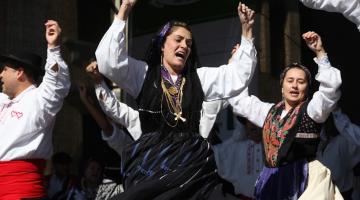 mulheres danças fado com roupas típicas elas rodam e estão  com as mãos para o alto. #paratodosverem