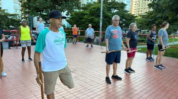 idosos fazem ginástica localizada em área livre. #paratodosverem