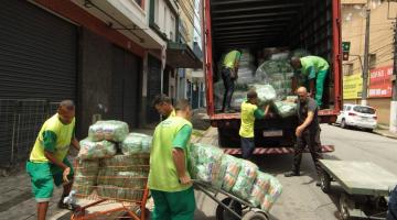 homens colocam doações em caminhão #paratodosverem 