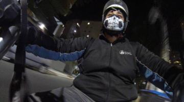 mulher usando máscara e capacete está sentada em moto. A foto parece uma selfie tirada a partir do guidão da moto. #paratodosverem