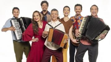 grupo de sete artistas posa para foto. Três deles, todos homens, tocam sanfona. #paratodosverem 