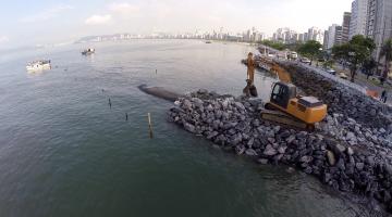 Barreira de pedras na Ponta da Praia exibe avanço do projeto piloto contra erosão. Veja fotos e arte