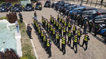 guardas municipais e viaturas perfilados em praça ao ar livre. #paratodosverem
