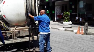 Homem opera equipamento de hidrojateamento de caminhão em galeria na rua. #pratodosverem