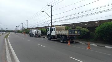 dois caminhões parados em avenida para fazer hidrojateamento e recolher resíduos. #paratodosverem 