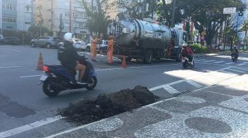 caminhão para serviços de drenagem está na avenida. junto à guia há um monte de areia. #paratodosverem