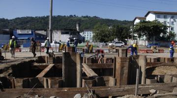 Obras em andamento. Homens estão próximos a grande escavação. #Paratodosverem