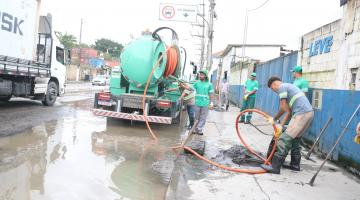 caminhão e homens trabalhando ao lado de alagamento. #paratodosverem