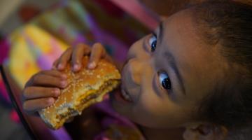 menina come sanduíche e sorri para a foto. #paratodosverem