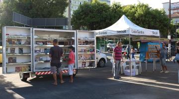 biblioteca móvel parada em praça com pessoas escolhendo livros - foto: arquivo/PMS