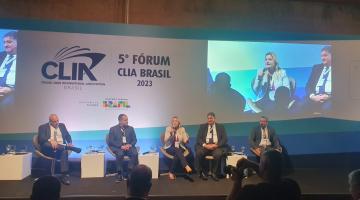 cinco pessoas reunidas em um palco fazendo palestra. #paratodosverem