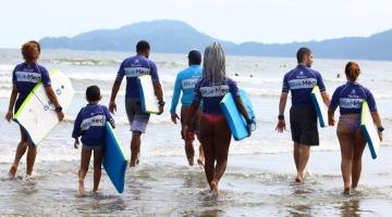 alunos entrando na água com pranchas #paratodosverem 