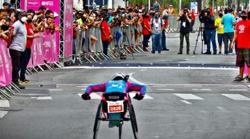 atleta na cadeira de rodas se aproxima da chegada na prova #paratodosverem