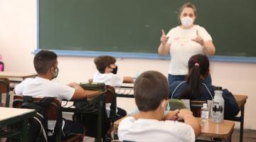 Professora na frente e alunos sentados assistindo a aula #paratodosverem