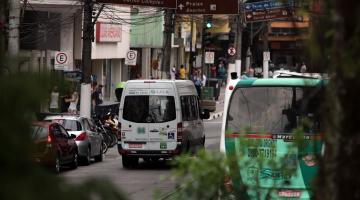 ônibus e van transitando em rua. #paratodosverem