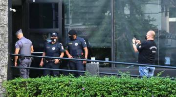 Guardas municipais, policial militar e fiscal estão na porta de estabelecimento.#paratodosverem