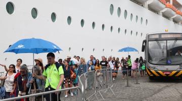 fila de passageiros para ingressar em navio atracado no porto. #paratodosverem 