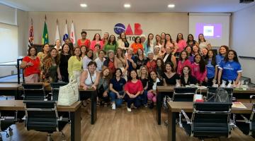 mulheres reunidas em auditório posam para foto. #paratodosverem 