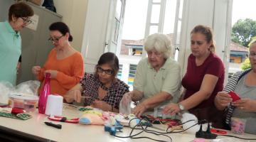 pessoas fazendo enfeites de Natal #paratodosverem 