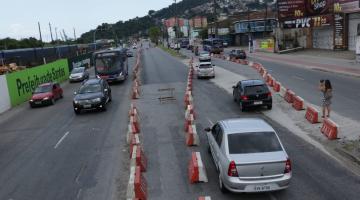 Carros trafegam nos dois sentidos em pistas demarcadas com barreiras plásticas. #pracegover