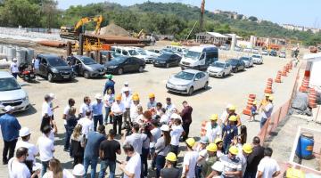 Representantes da Caixa e da Prefeitura se reúnem em canteiro. #pracegover