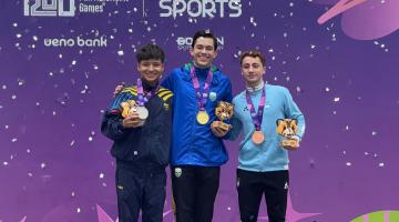três atletas em pódio com medalhas. #paratodosverem