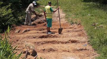 homens começam a fazer degraus de escada em área com vegetação. #paratodosverem