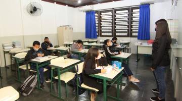 alunos estão sentados em carteiras. Professora na frente de todos. #paratodosverem