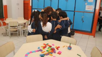 crianças abraçam professora #paratodosverem