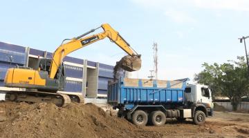 máquina coloca areia em caminhão #paratodosverem