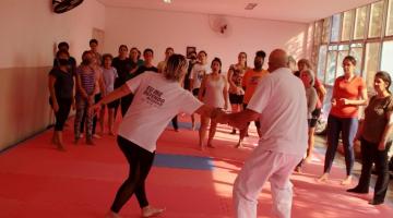 instrutor faz movimento com mulher #paratodosverem