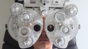 exame oftalmológico em criança. Equipamento em primeiro plano. #paratodosverem