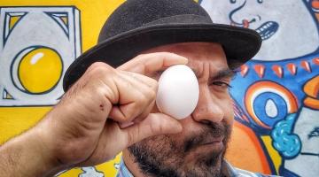 Artista posa para foto com um ovo na frente do olho #paratodosverem