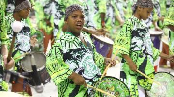 Ritmistas fantasiados em desfile de carnaval. #paratodosverem