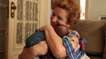 Mulher abraça criança no colo #paratodosverem