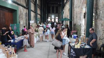 pessoas olhando produtos em feira #paratodosverem