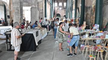 pessoas olhando produtos em feira #paratodosverem
