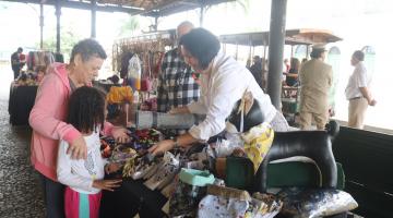 pessoas olhando produtos em feira #paratodosverem