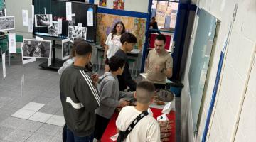 alunos olhando trabalhos na feira #paratodosverem