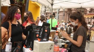 Mulher é servida em tenda de café no bulevar da XV de Novembro. #pracegover