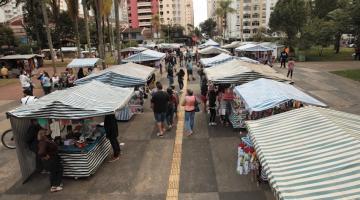 barracas da feirart em praça com movimentação de pessoas. #paratodosverem